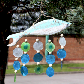 Weiß-blaue Fischschnitzerei und bunte Muscheltropfen