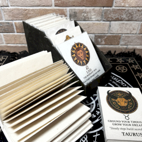 12x Mittleres Notizbuch im tibetischen Stil mit Sternzeichen – (12 x 8 cm) – 40 Blätter (12 x verschiedene Designs) – in Vitrine